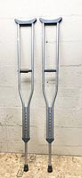 Full view of both aluminum crutches standing upright showing overall condition