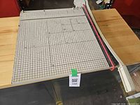 Top view of guillotine cutter showing grid surface swing arm and red safety strip