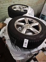 Two alloy wheel/tire assemblies stacked, Audi center cap visible