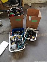 Overview of three totes and one box with assorted tools and bike parts