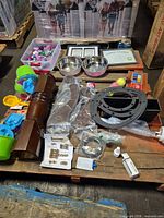 overview of entire lot on pallet showing wooden legs, pet bowls, toys, hardware, gaskets
