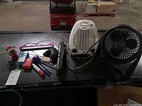 Group shot showing fan, heater, hole punch, mouse, stationery items, staple boxes, solar bobblehead