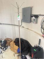 Full view of beige metal coat rack standing in room