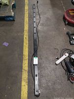 Full length view of black vertical PDU with cord attached