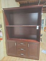 Front view of tall dark cherry bookcase hutch showing open shelves and closed lower doors/drawers