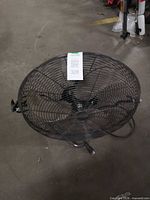 Overall view of the Commercial Electric 20-inch fan showing cage, blades, cord and mounting bracket