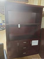 Front view of dark brown hutch showing open top section, lower drawers and cabinet door