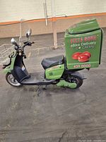 Left side view showing full scooter, delivery box, frame and wheels