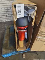 Opened carton showing rear section of red bicycle with seat and fender
