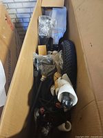 Packed e-bike frame, fork, handlebars and wrapped parts inside shipping carton