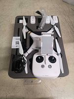 Drone, controller, batteries, propellers, charger in foam tray