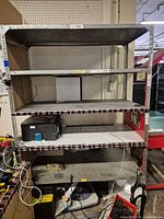 Full frontal view of galvanized steel shelving rack showing four shelves and overall condition