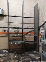 Full view of assembled gray steel shelving with several shelves and uprights