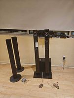 Four tower speakers standing on floor, cables visible
