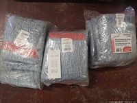 Three sealed packages of Johnny Vac light blue string mop heads