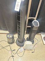 Four electric appliances grouped: tower fan, two tower/compact heaters, cords visible