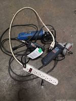 Group of two angle grinders, soldering gun, power strip and cords