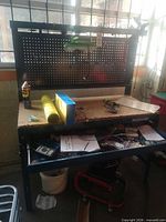 Front view of workbench showing pegboard, lamp, particleboard top, drawer