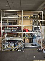 full view of two beige metal shelving bays with five shelves each, contents present for scale only