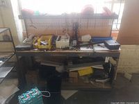 Front view of workbench with pegboard, overhead shelf, lower shelf and various items