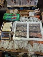 Overview of lot on pallet showing frames, refrigerator drawer front, frosted shades, scissor jack boxes, hardware box