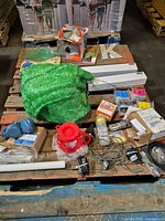 Overall pallet showing artificial turf, ink cartridges, cables, sockets, motor, red funnel, letter K and boxed items