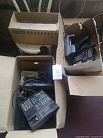 Two open boxes containing Nortel corded office phones with handsets and wiring