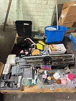 Overall view showing pallet with mop bucket, grille parts, chrome rack, file bin, toys and assorted items