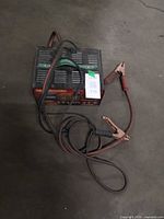 Full view of MotoMaster charger with attached leads on floor