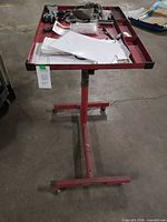 Full view of red steel rolling work tray showing tray, post and base