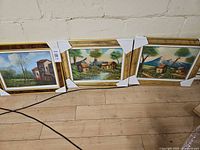 All three framed landscape prints side by side on floor