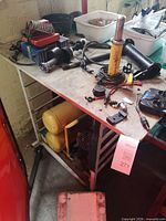 View of compressor under bench and assorted tools on work surface