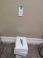 Stack of three white tablet boxes on floor