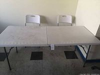 Full view of 6 ft folding table with two folding chairs