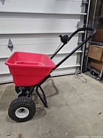 Side view of spreader showing hopper, frame and one pneumatic tire