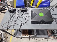 Console, two controllers and cables on table