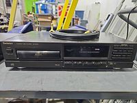 Front view of Technics SL-PG100 CD player with coiled RCA cable on top