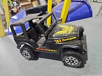 Side view of black Tonka Renegade Jeep showing decals and tire branding