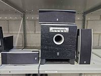 Front view of subwoofer with two vertical satellites and one horizontal satellite