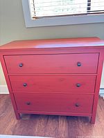 Front view showing three drawers and black knobs