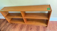 Front view of teak veneer bookcase showing three open tiers