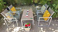 overview of patio table, four chairs, pillows, and square planter