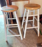Two white-leg wood stools side by side