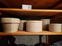 Shelf view showing two planters and three crocks