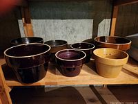 Group shot of all seven glazed clay planters on shelf