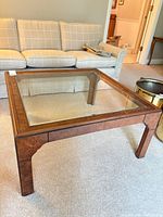 Overall view of square wood frame coffee table with glass insert