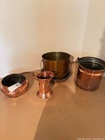 Group shot of all four copper vessels and terracotta pot