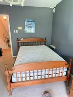 Full view of double wooden bed frame showing headboard, footboard and side rails