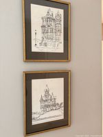 Both framed sketches hanging on wall showing size and matching frames