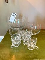 Group view of two fish bowls, cylindrical bowl, and several punch glasses